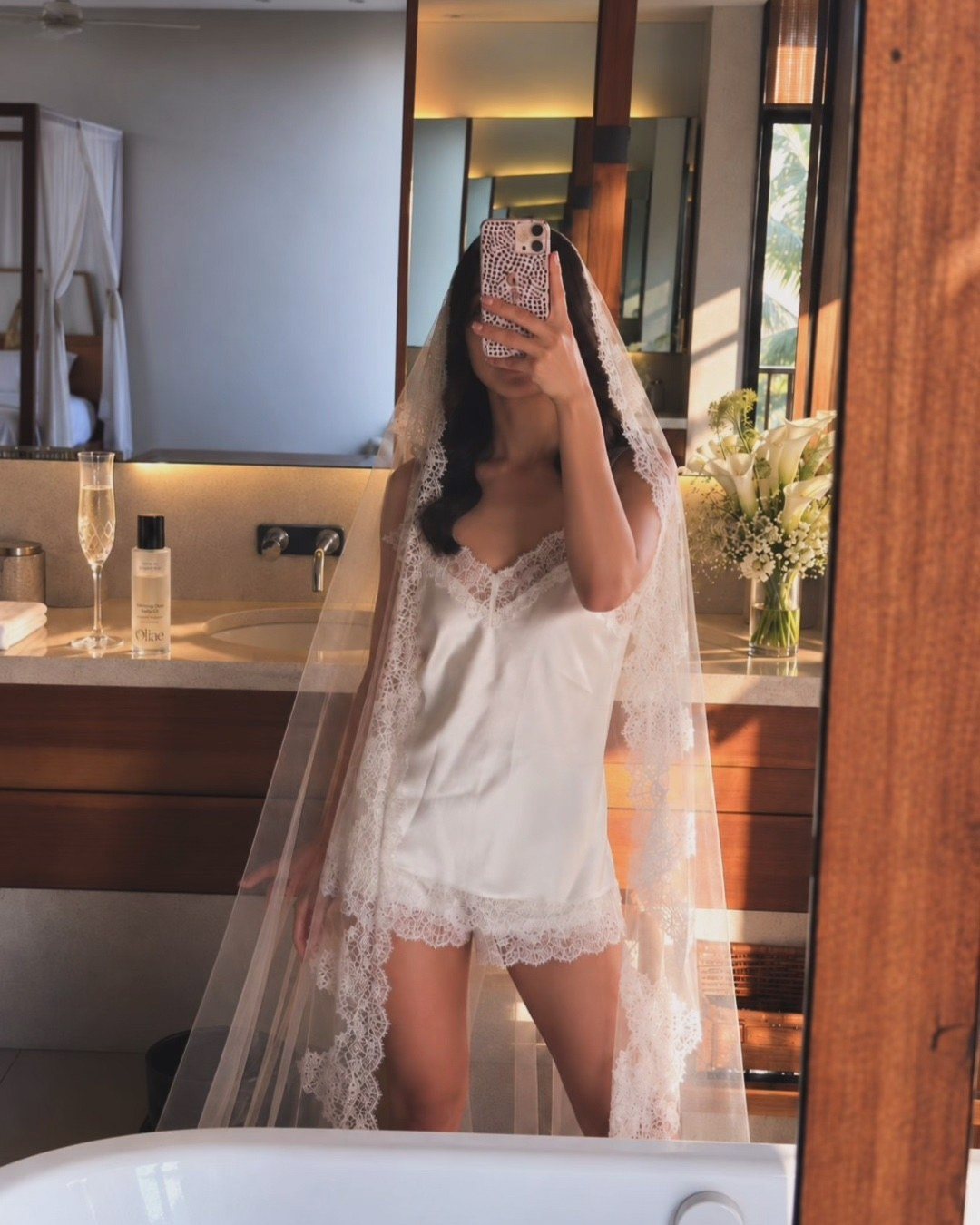 Amelia, the founder, in a sunlit bathroom with a bottle of Morning Dew Body Oil on the counter